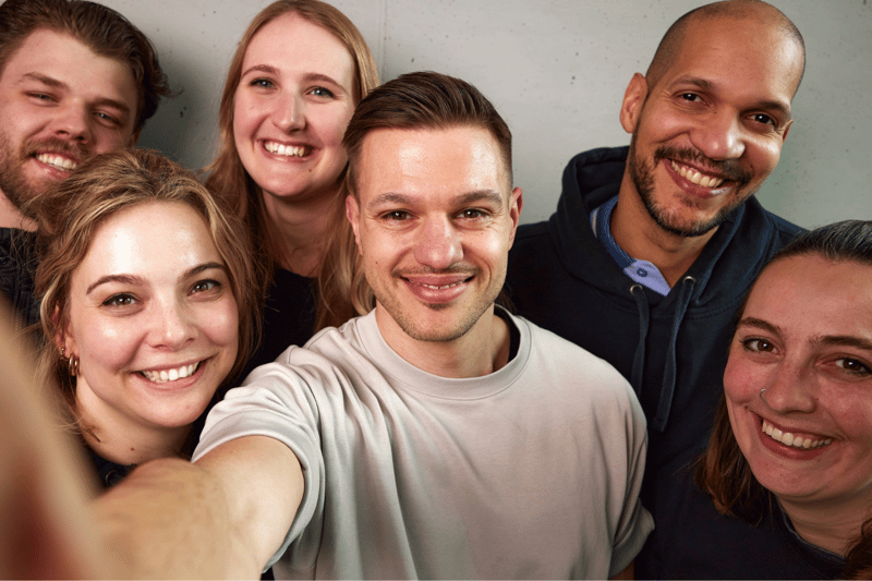 Verschiedene Mitarbeitende von Team netgo machen ein fröhliches Selfie-Foto