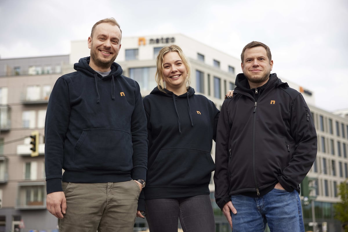 Foto von 3 Mitarbeitenden mit netgo Pullover in schwarz vor dem Berliner Headquarter